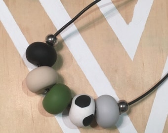 Polymer clay bead necklace. Spots black white green