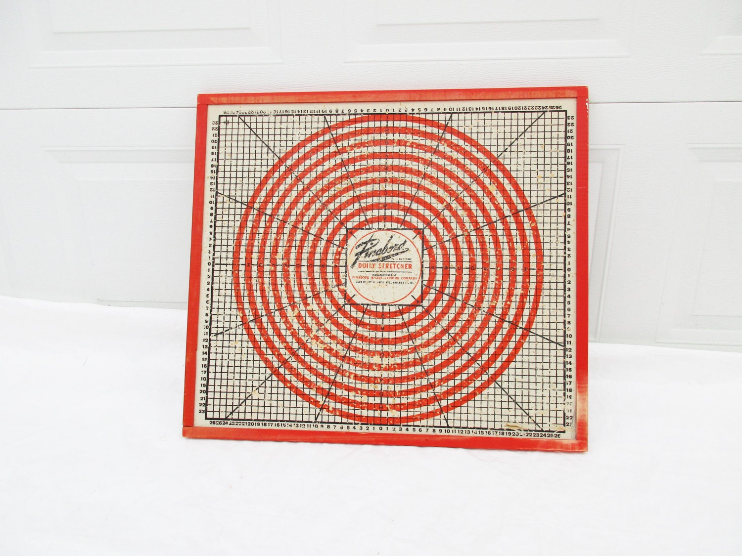 A 'Pinabord' Doily Stretcher with Wood Frame - Red/Orange 