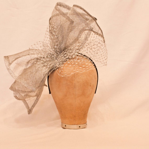 Handmade large silver asymmetric bow ladies hat decorated with silver veiling
