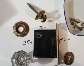 Salvaged crystal and thumb latch doorknobs with mortise and key hole covers.
