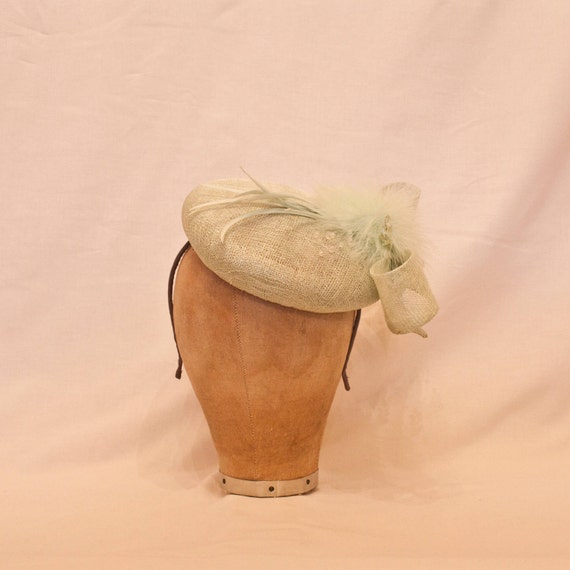Handmade pale green ladies occasion hat, decorated with bow, delicate feathers & beading