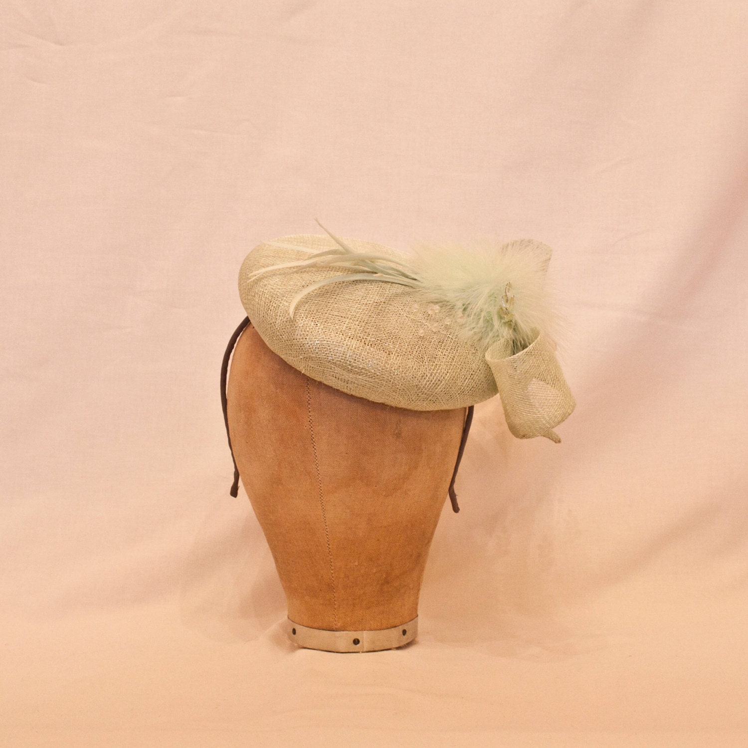 Handmade pale green ladies occasion hat, decorated with bow, delicate feathers & beading