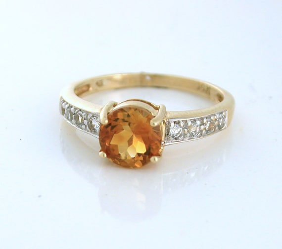 Orange Sapphire, Round, with diamonds on the shank. 14k yellow gold