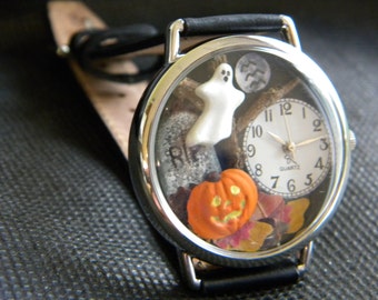 Spooky Halloween Watch with glow-in-the-dark pumpkin face and edge of ghost with autumn leaves tombstone moon bats and dead tree