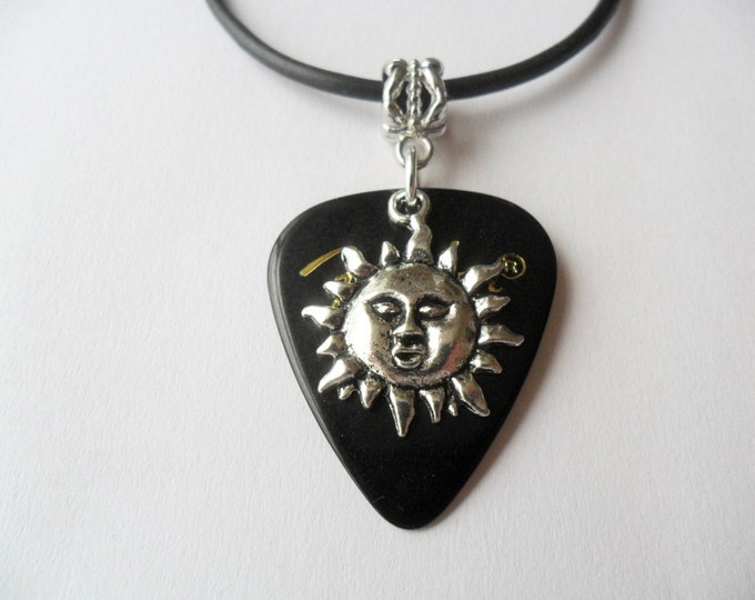 Black Guitar pick necklace with silver tone sun charm that is adjustable from 18" to 20"