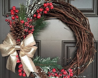 Rustic Christmas wreath with gold bow, red berries, greenery and pinecones; monogram wreath