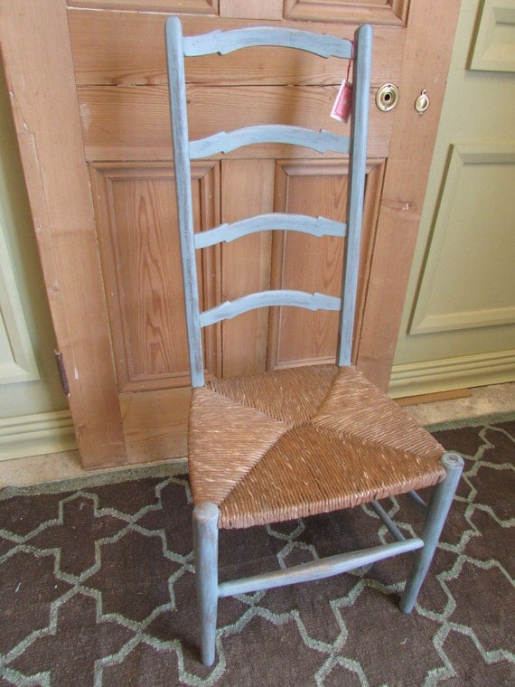 A blue painted ladder back chair with rush seat