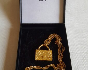 Authentic and Rare Chanel necklace representing the mythical bag of home Couture Chanel in its box.