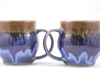 pair of handmade mugs. large pottery mugs. flowing deep blue glaze. handmade in ithaca. under the tree.