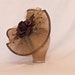 Handmade coffee brown coloured show stopping hat decorated with beading and a silk rose