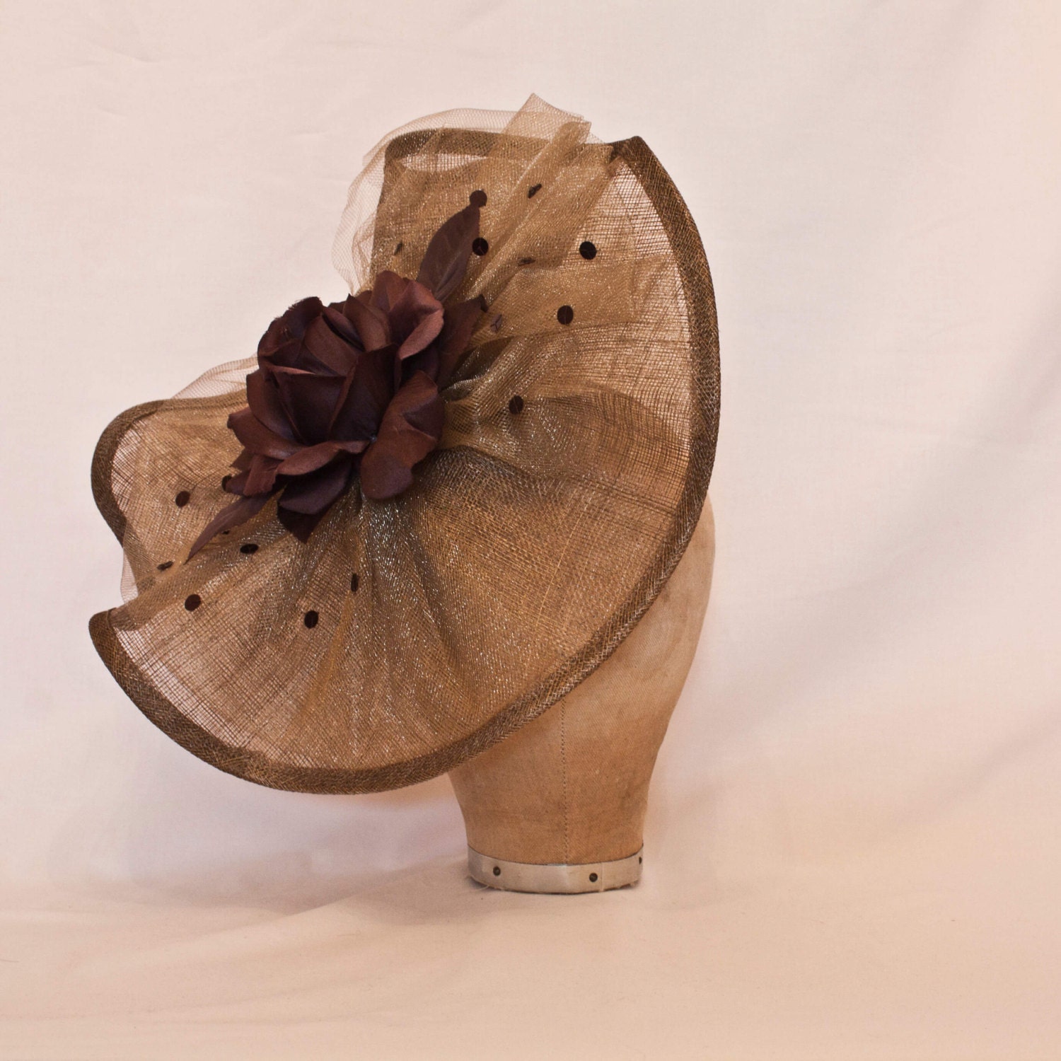 Handmade coffee brown coloured show stopping hat decorated with beading and a silk rose