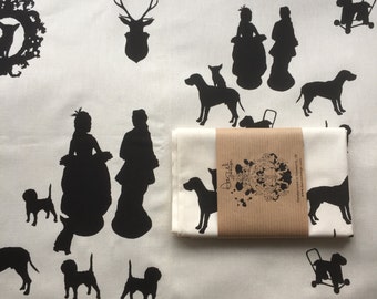 Screen-printed tea towel with silhouettes featuring figurines, dogs and a stag's head