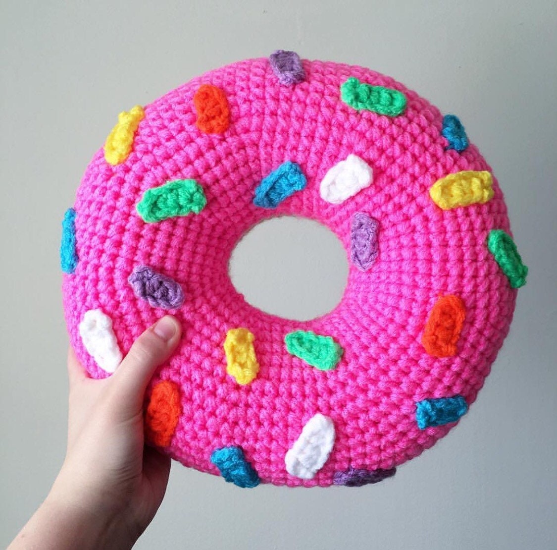 Crochet Pink Frosted Donut Pillow with Rainbow by OliviaLawsArt