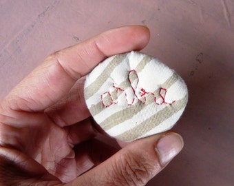Textile brooch with embroidered French word ARBRE (tree)