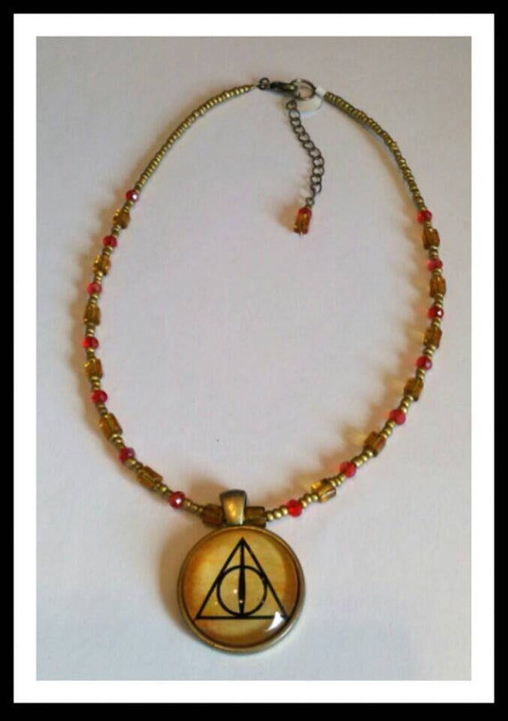 Items similar to Handmade Gold Toned Harry Potter Deathly Hallows Necklace with Red Crystals and