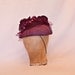 Plum/purple occasion hat decorated with rose, tulle and beading