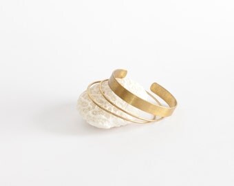 Set of 3 simple brass cuff bracelets : one large one with a brushed textured finish, and two delicate thin ones