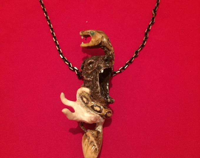 The bone amulet. The snake with eyes of green quartz wounds around the bear