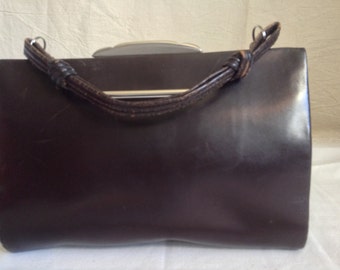 Brown leather pouch, clasp metal, anse à nodes, lay hands.