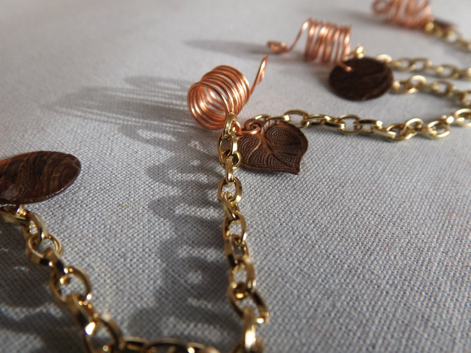 Loc hair jewelry with coppercolored charms and connected by