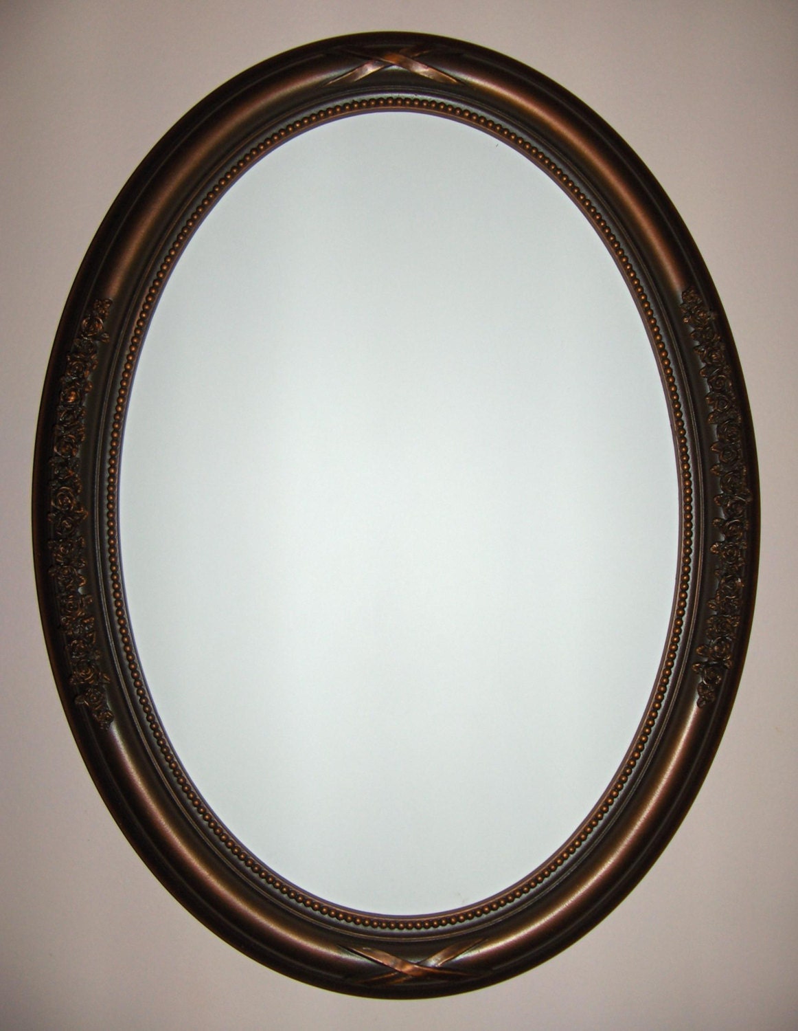 Oval mirror with oil rubbed bronze color frame. bathroom
