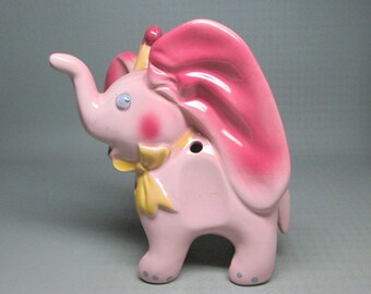 pink pottery elephant with 4 holes in it , maybe a barware item ?