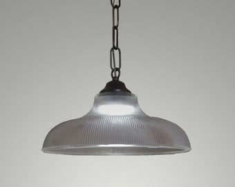 Large glass pendant lighting on a brass chain. Hanging large glass lighting fixture on a dark brass chain with a brass ceiling canopy