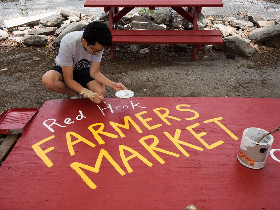 An Etsy employee paints a sign for the Red Hook Farmers Market An Etsy employee paints a sign for the Red Hook Farmers Market