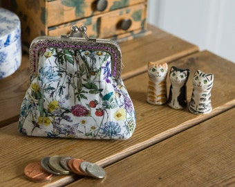 Coin purse made with wild flower print Liberty Tana Lawn outer, navy cotton interior, and a hand stitched silver colour metal frame