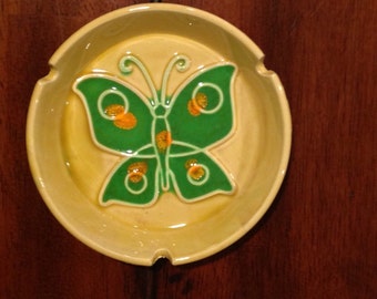 Vintage ceramic butterfly ashtray. Round with nice yellow color and green butterfly with orange details. Made in Japan. Measures approximate