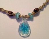 Handmade hemp necklace with glass blue flower pendant