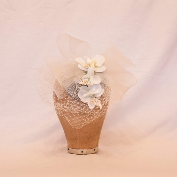Pretty silver hat decorated with white orchids, a tulle bow and veiling