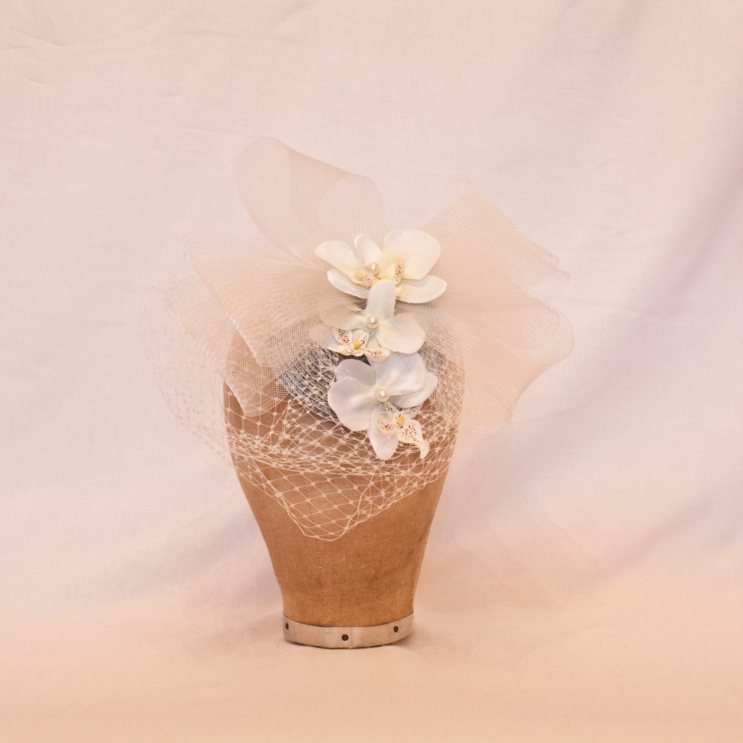 Pretty silver hat decorated with white orchids, a tulle bow and veiling