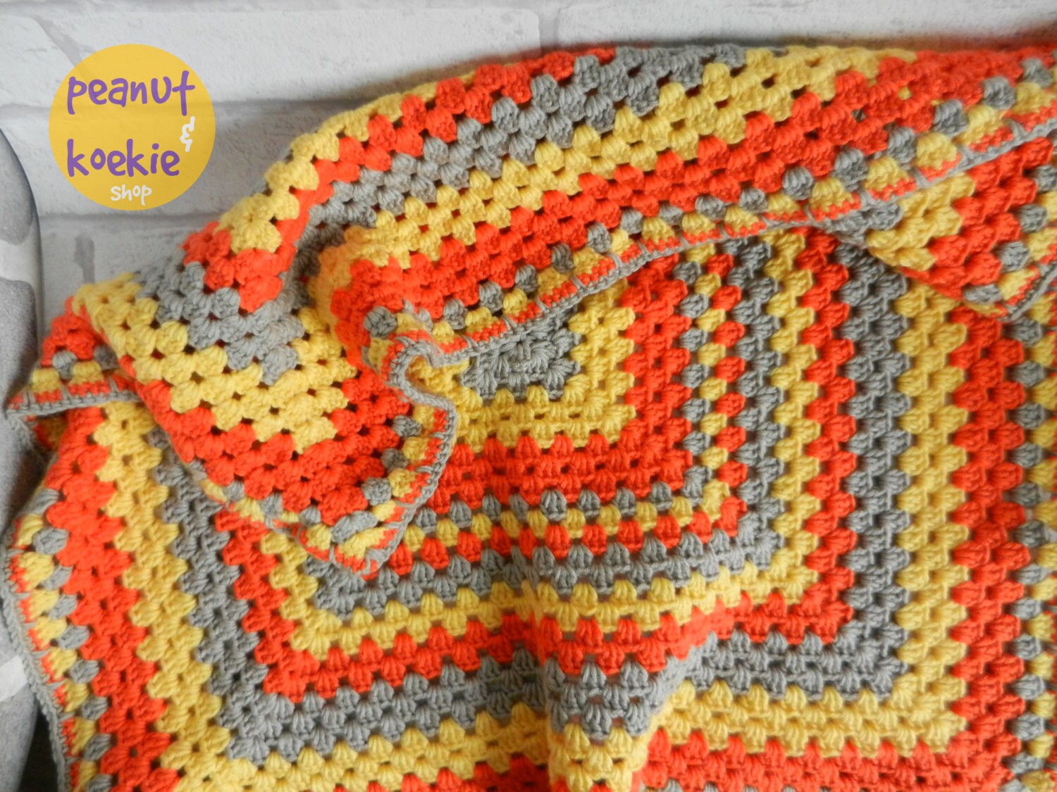 Crochet granny square blanket in yellow orange and grey