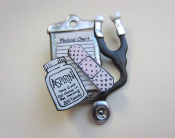 Medical pin with aspirin, stethescope, bandaid, and medical chart brooch