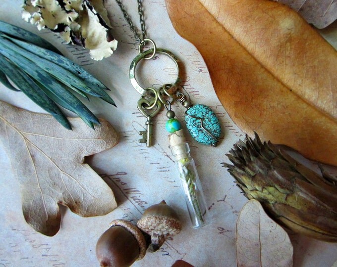 Necklace "Steppes of Narnia" with glass vial with dried flower, key charm, and turquoise pendant on a hammered ring. Custom length chain.