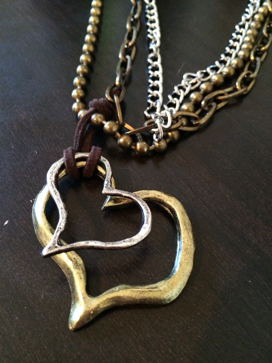 Hammered Metal Dual Heart Charm on Brown Rope attached to