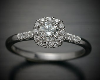 14kt white gold Diamond Engagement ring with a round center and cushion halo