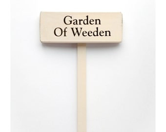 Garden Stake Sign Saying "Garden of Weeden" White Wood Sign With Saying in Black Lettering.