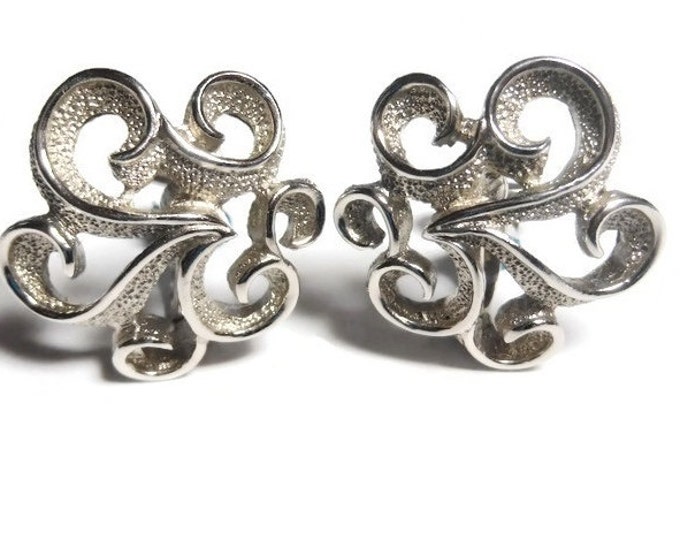Crown Trifari earrings, silver swirls flash the light with the textured pebble effect and the satin trim, clip earrings