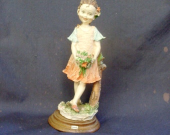 statua di bambina, statue of a little girl gathering flowers in the woods, leaning against the trunk of a tree, a smile in his cheeks pink