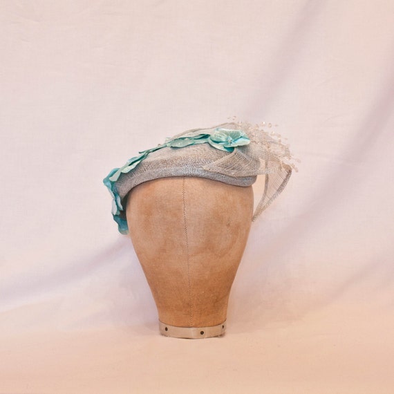 Handmade pale blue ladies occasion hat, decorated with delicate blue flowers
