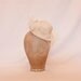 Small ivory bowler hat shaped fascinator with veiling and pearl bead detailing