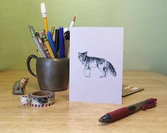 Coyote note card. Black line drawing of a coyote, blank inside with text on the back about coyote the trickster.