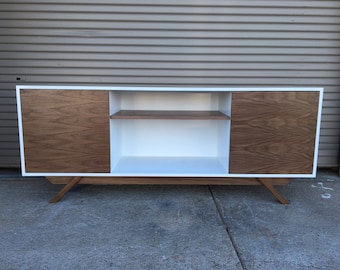 NEW Hand Built Mid Century Inspired TV Stand. Two Door w/ center shelf and angled leg base. White lacquer body w/ Walnut Doors & Leg Base.