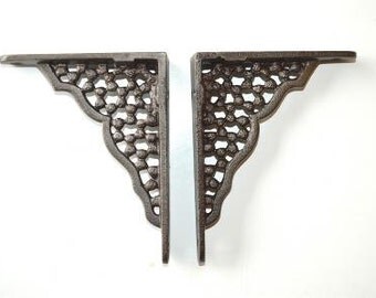 A pair of small cast iron honeycomb shelf brackets