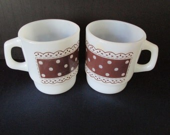 A Pair of Fire King Brown Polka Dot and Lace Stackable Coffee Mugs