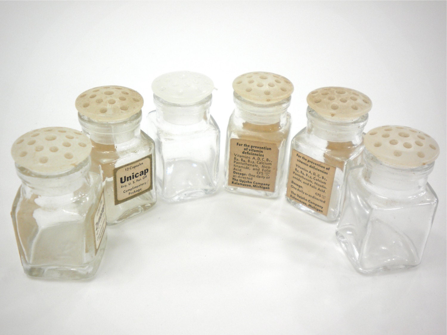 6 small clear glass vitamin bottles with plastic lids tiny
