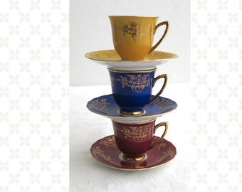3 demitasse cups and saucers, yellow, blue, burgundy with gilt edges and gilt floral bouquets, Czechoslovakia, RGK, 1928 - 1938