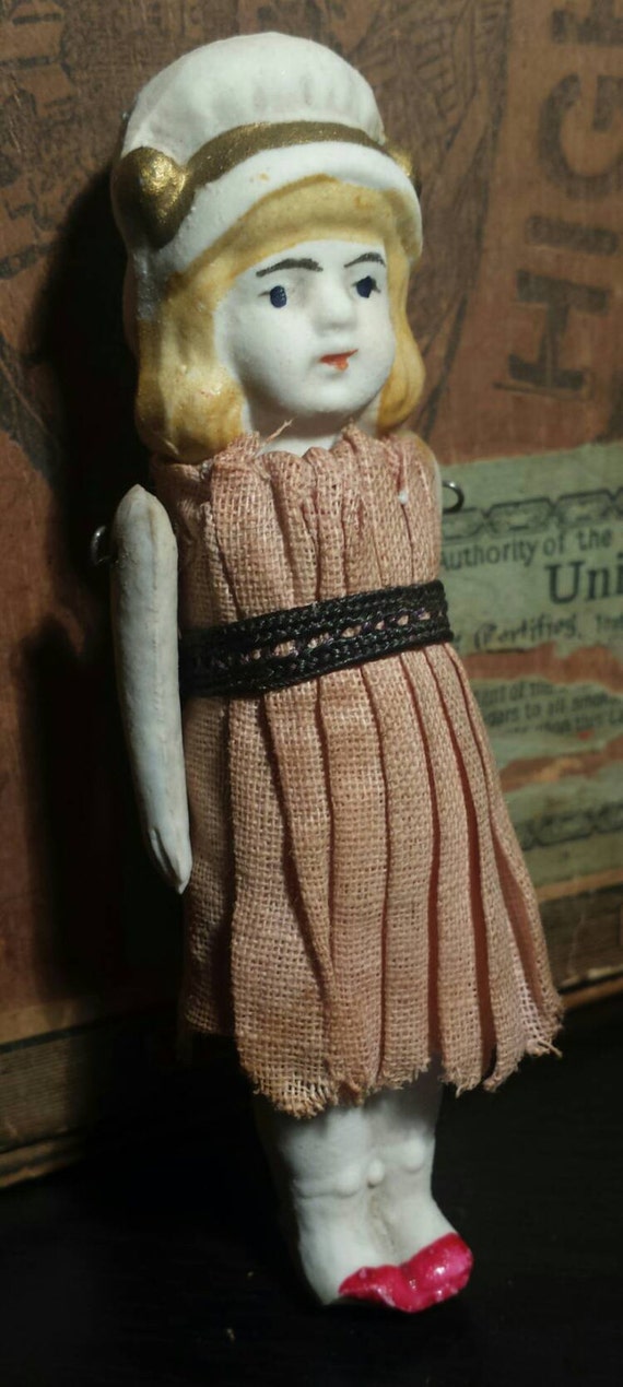 Early 1900's bisque porcelain jointed doll with clothing.